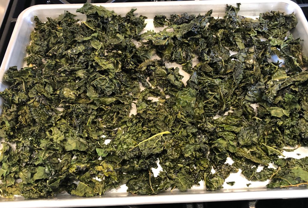 Fully roasted kale chips on a sheet pan