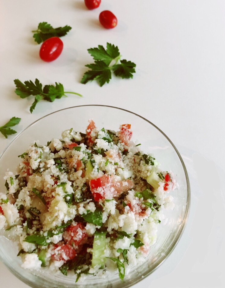 a glass bowl filled with cauliflower tabbouleh
