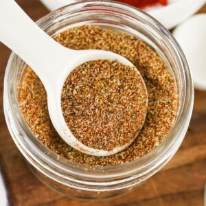 Authentic Homemade Taco Seasoning Recipe in a mason jar with a white spoon