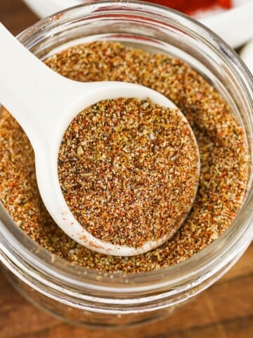 Authentic Homemade Taco Seasoning Recipe in a mason jar with a white spoon