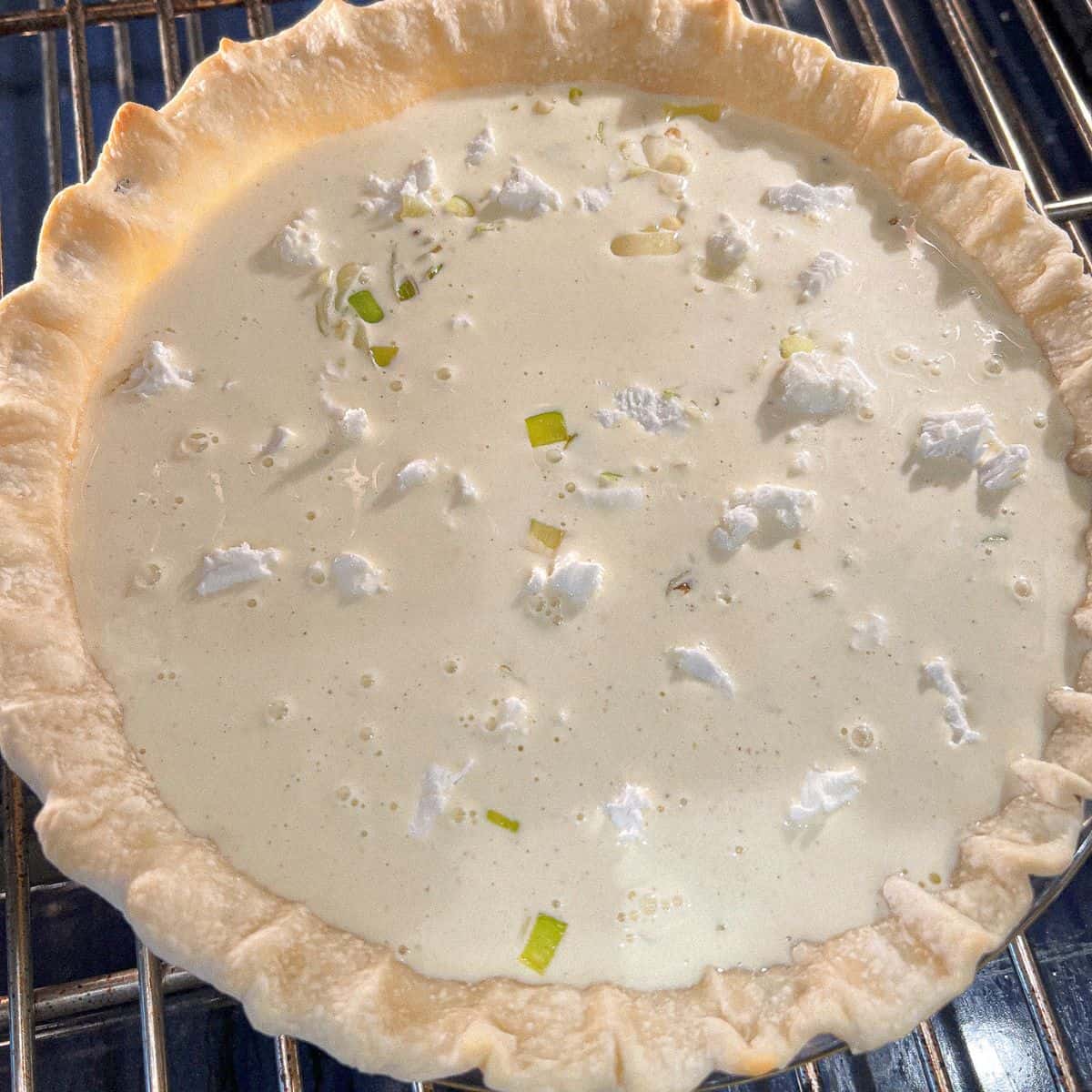 egg custard on top of leeks and goat cheese in a pie crust