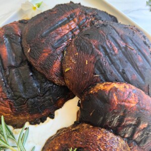 Quick low carb grilled and marinated portobello mushrooms on a white plate.