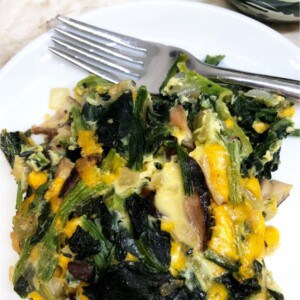 a white plate with a square of spinach and cheese casserole