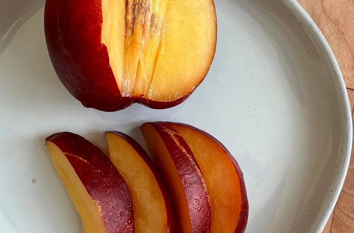 Sliced nectarines on a white plate.