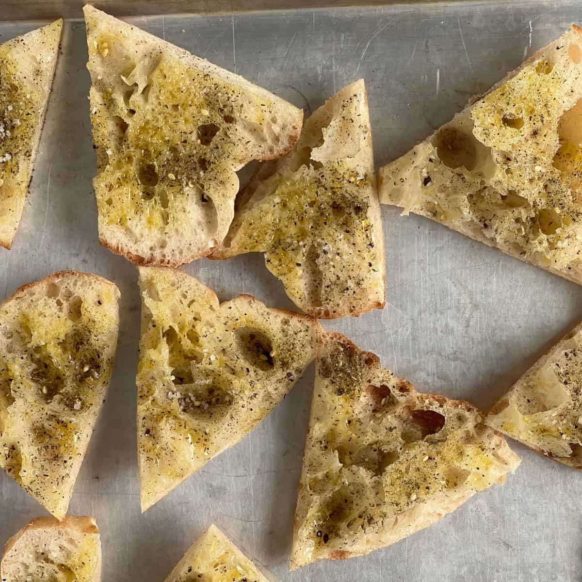 homemade pita chips on a sheet pan and sprinkled with salt and Za'atar