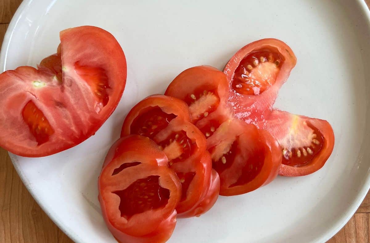 Sliced tomatoes on a white plate.
