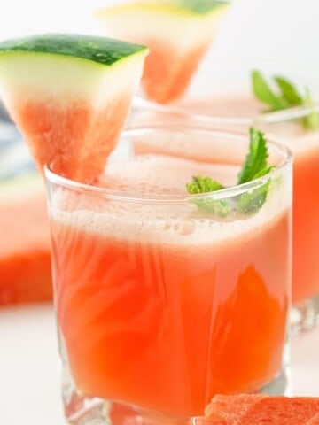 A glass of watermelon Agua Fresca with a watermelon garnish and mint.