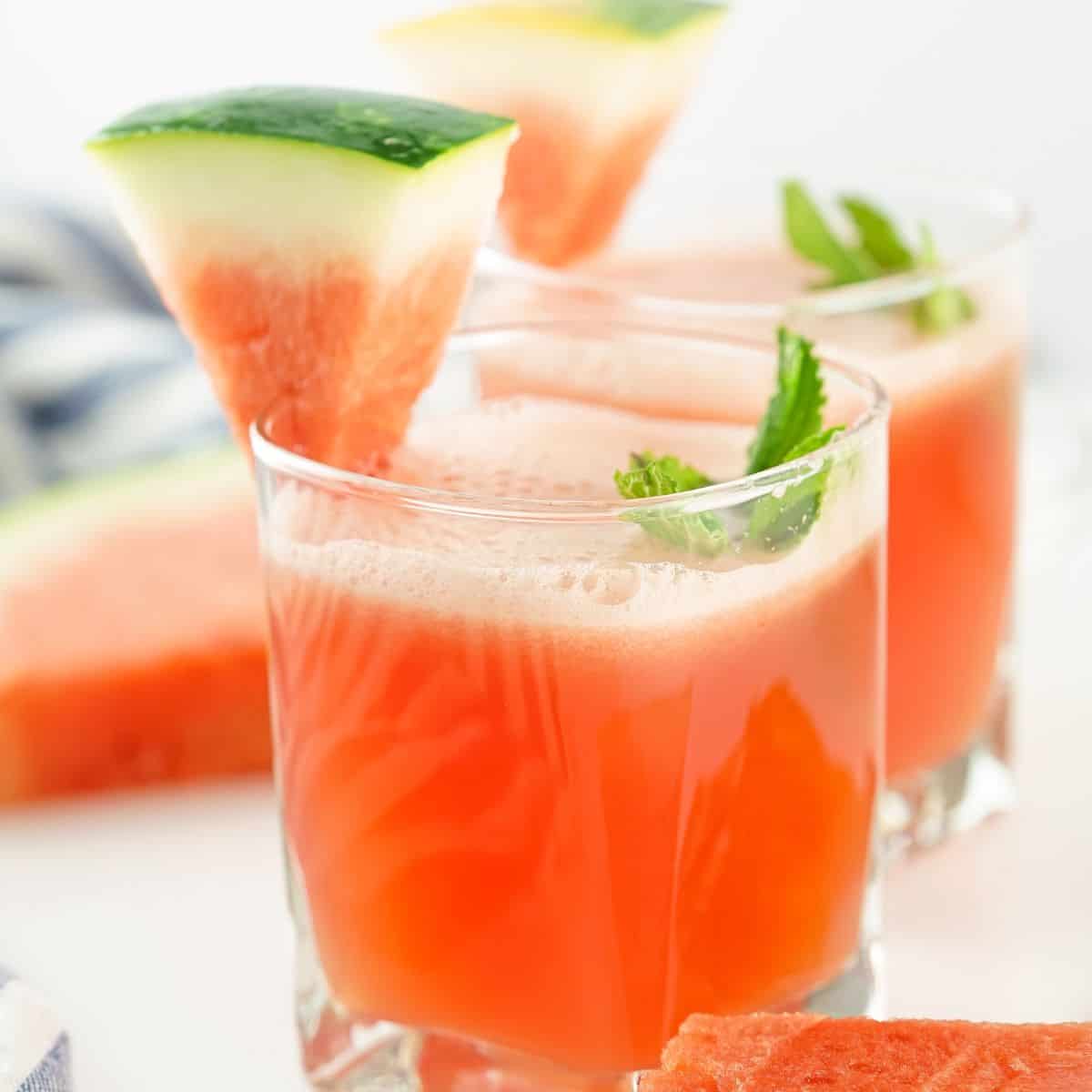 A glass of watermelon Agua Fresca with a watermelon garnish and mint.