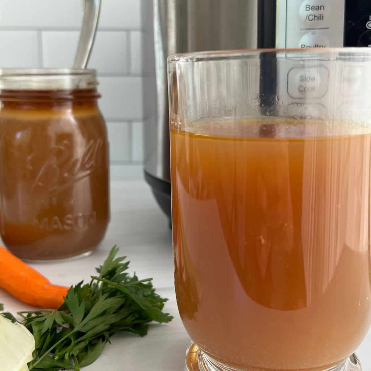 Bone broth in a glass mug with an instant pot in the background.