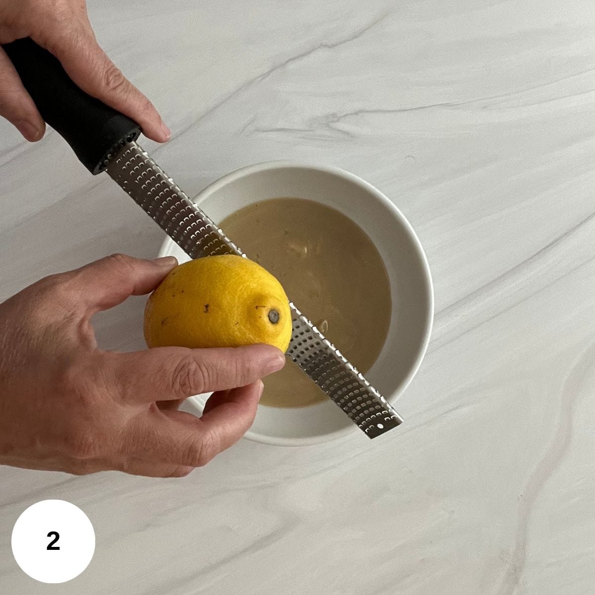 Grating lemon zest into the bowl. 