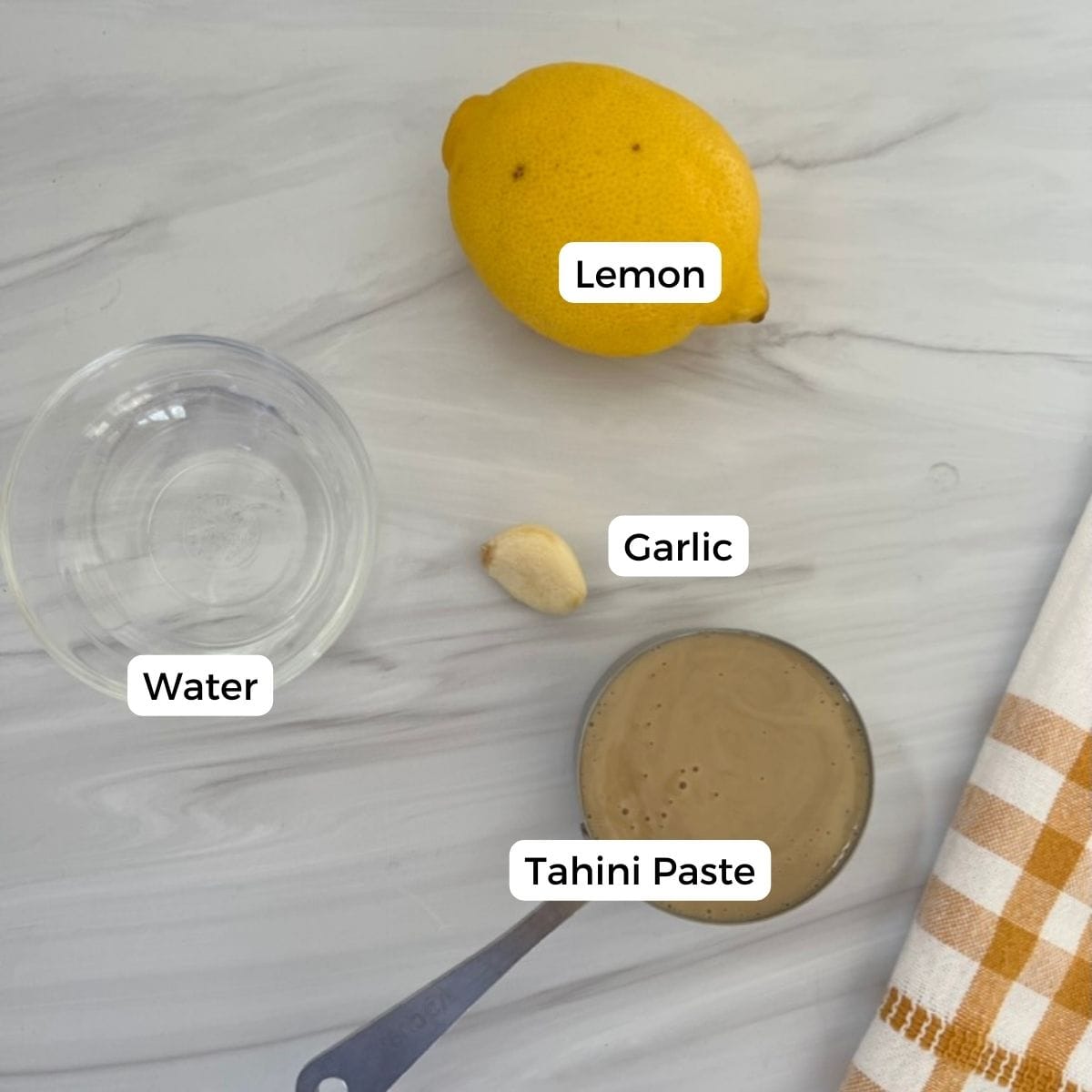 ingredients for the lemon garlic tahini sauce include lemon, garlic, tahini paste, and water. 