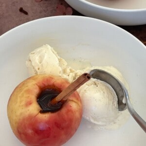 Portuguese Baked Apple With Cinnamon and Port in a white bowl with a spoon Featured Image