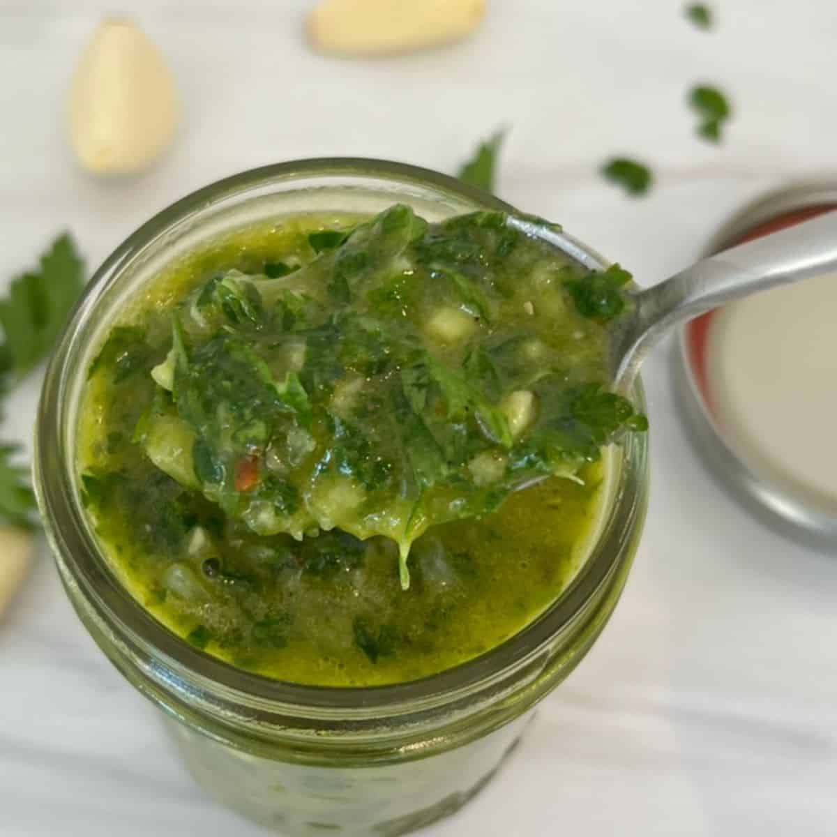 Easy Authentic Chimichurri Sauce Recipe with a spoon