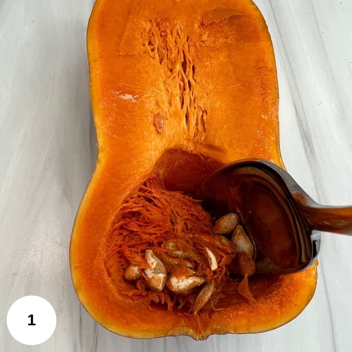 sliced squash in half and spooning out the seeds.