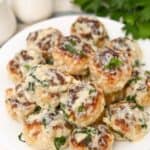 Keto turkey meatballs on a white plate with basil cream sauce and garnished with parsley