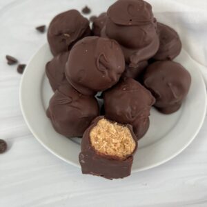 Peanut butter buckeye balls with rice krispies on a white plate.