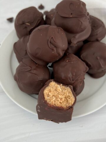 Peanut butter buckeye balls with rice krispies on a white plate.
