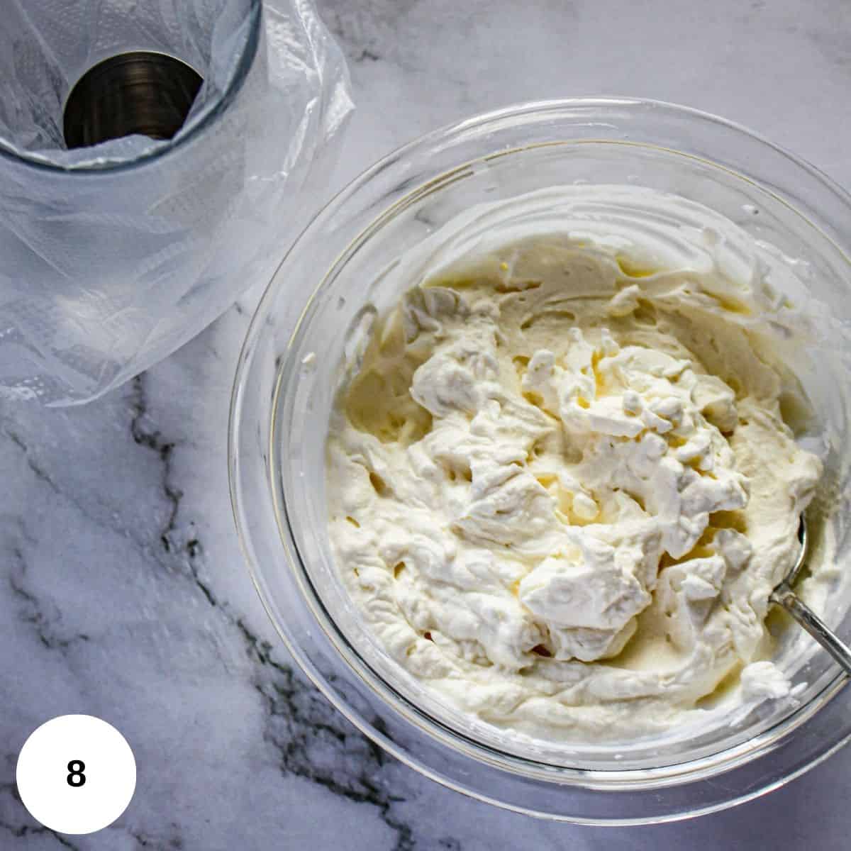 whipped cream in a clear bowl waiting to be piped onto the pie.
