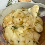 Portuguese Creamy Baked Cheese with Honey and Olive Oil with a spoon pulling the cheese.