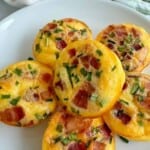 Bacon and gruyere egg bites on a white plate.
