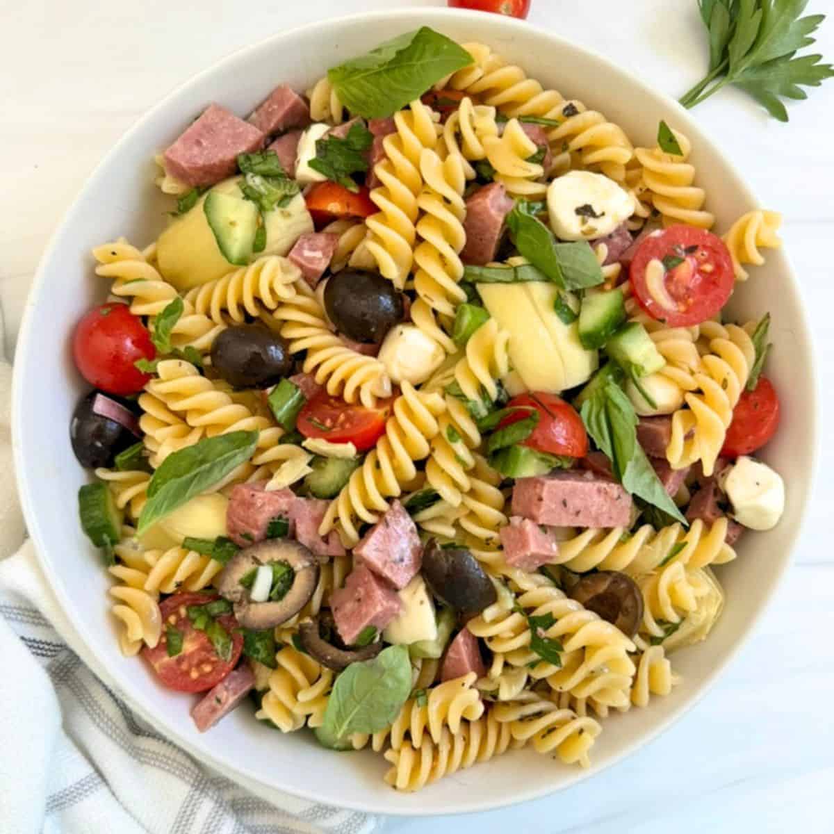 A gluten free pasta salad with salami, cheese, and vegetables. 