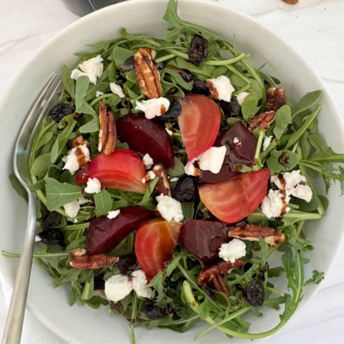 Arugula with beets, goat cheese, pecans, cranberries and a salad dressing. 