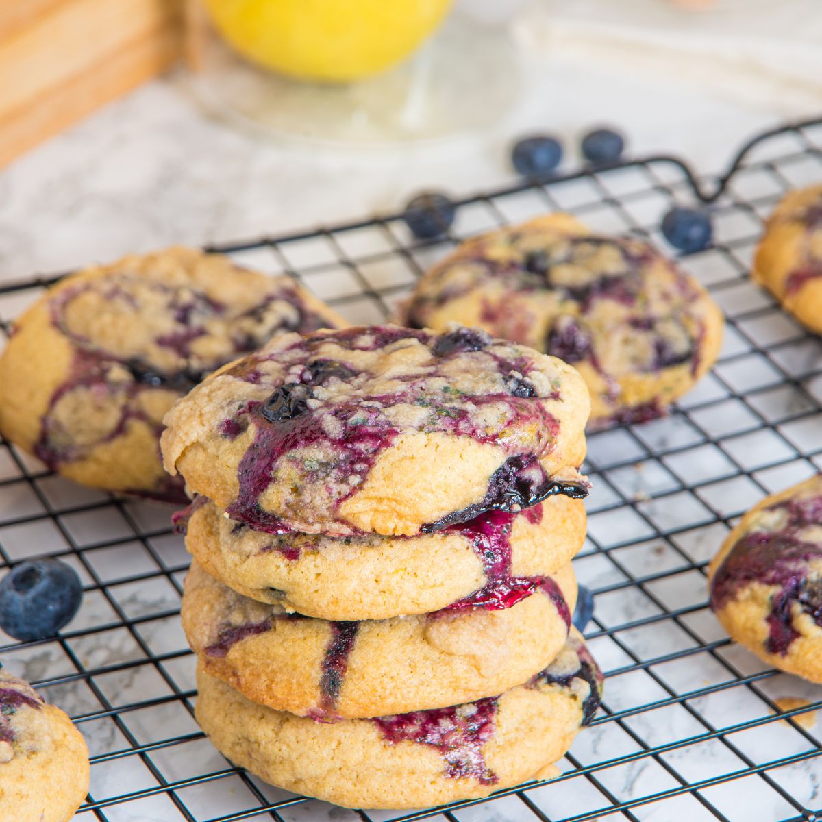 Lemon blueberry cookies stacked on a wire rack. 