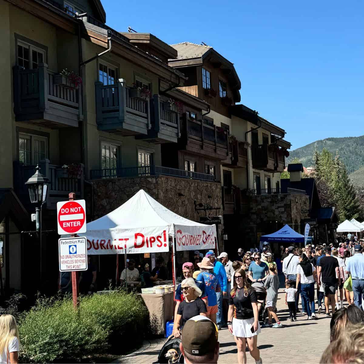 A picture of the downtown Vail farmers market showing stands and people.