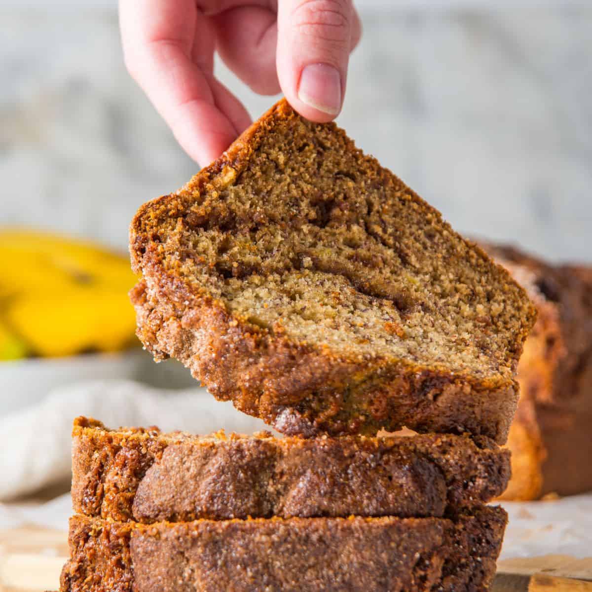 Holding a slice of cinnamon banana bread.