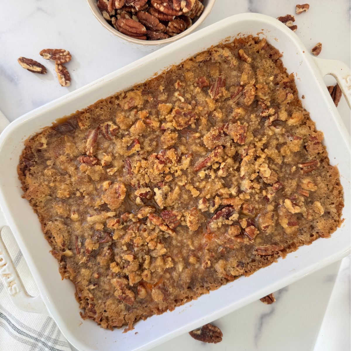 Gluten free sweet potato casserole in a white dish with pecan topping. 