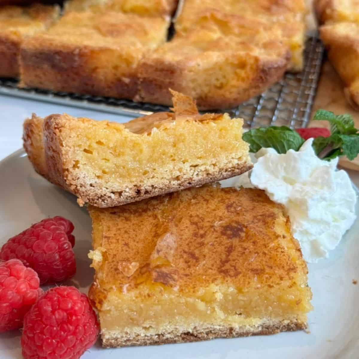 Gooey Butter Bars stacked on a white plate. 