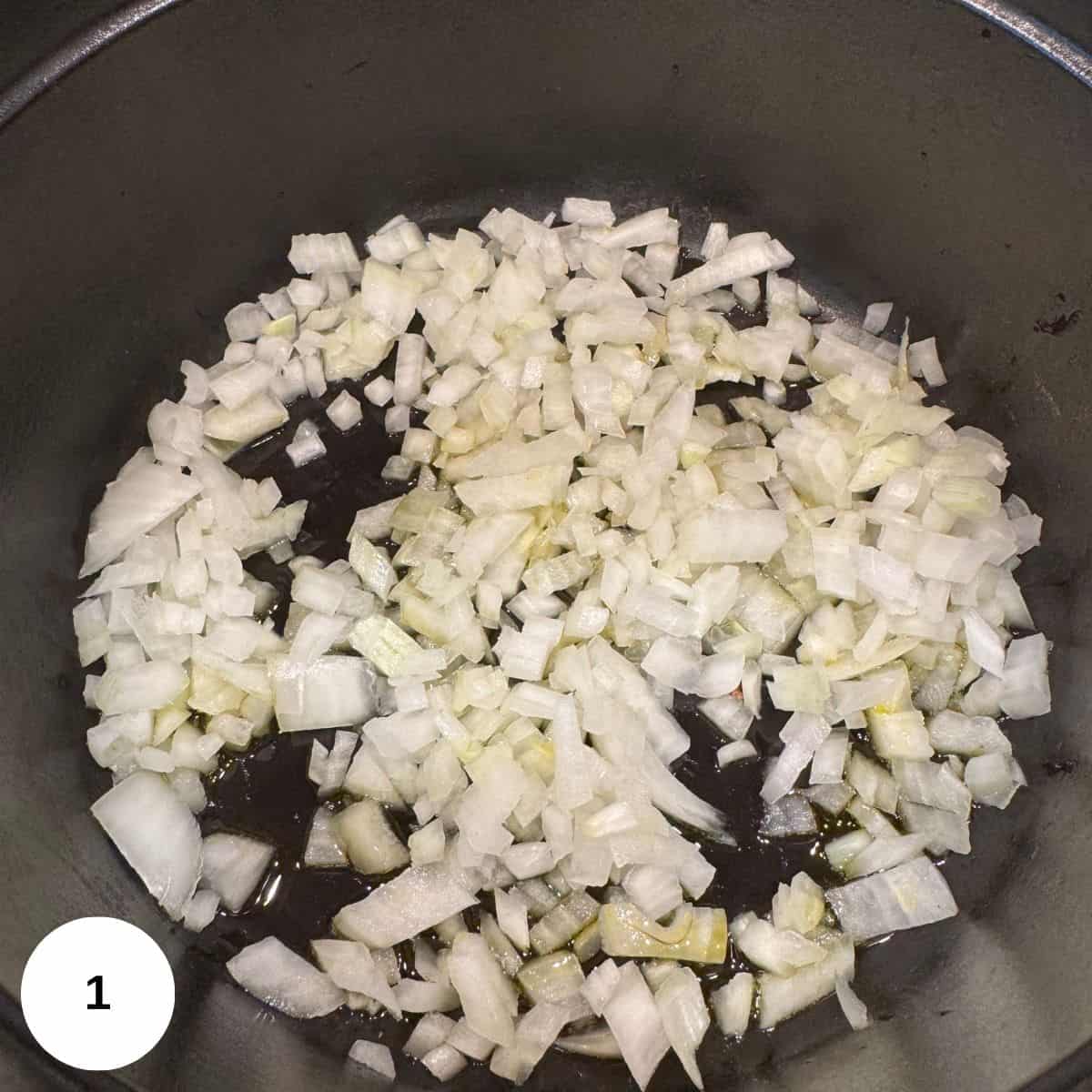 Cooking onions and garlic in olive oil in a Dutch oven pot on the stove. 