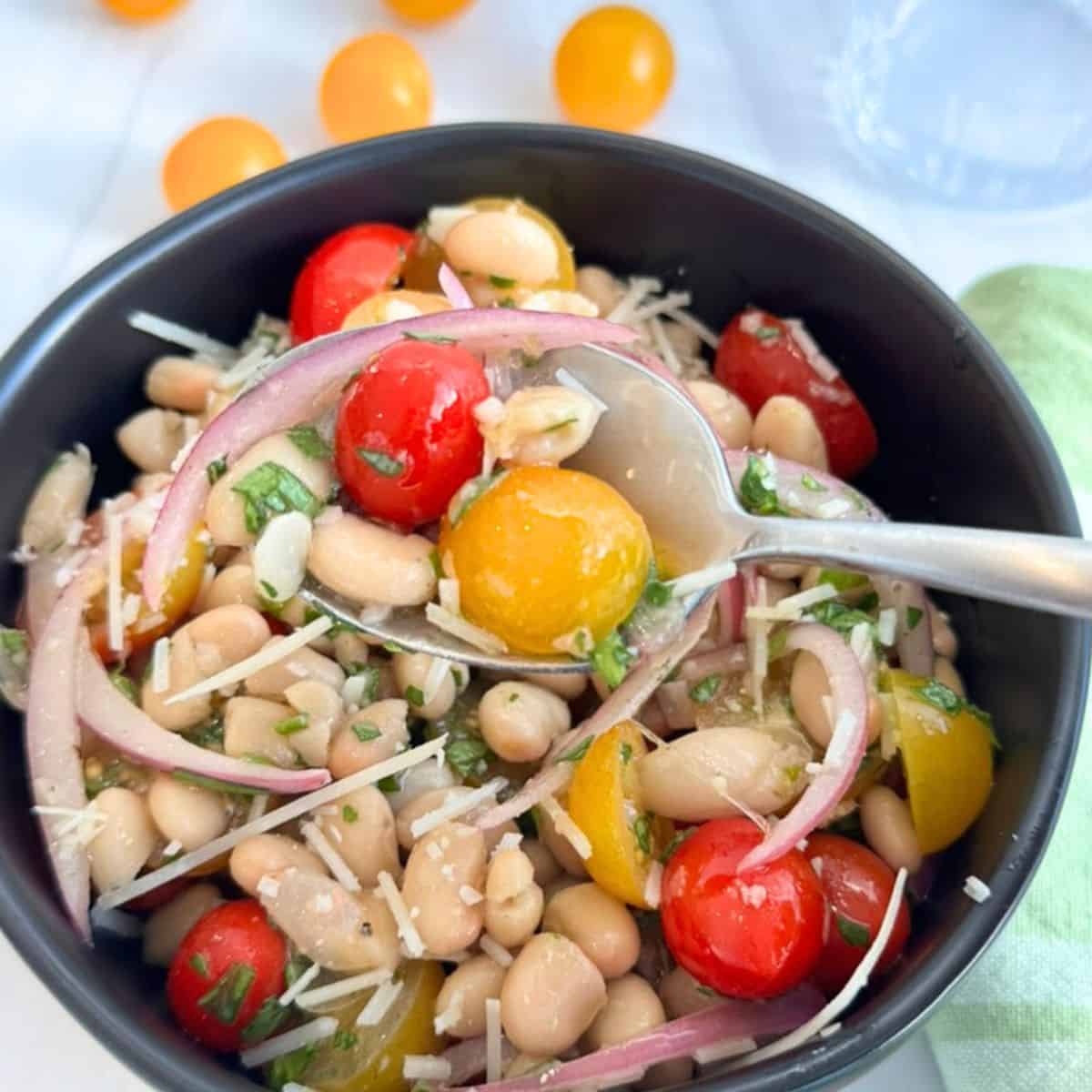 A spoon holding some of the white bean salad. 