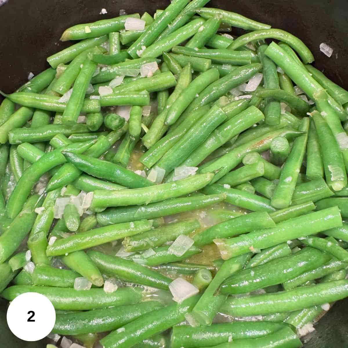 Adding in the broth and beans to the onions. 
