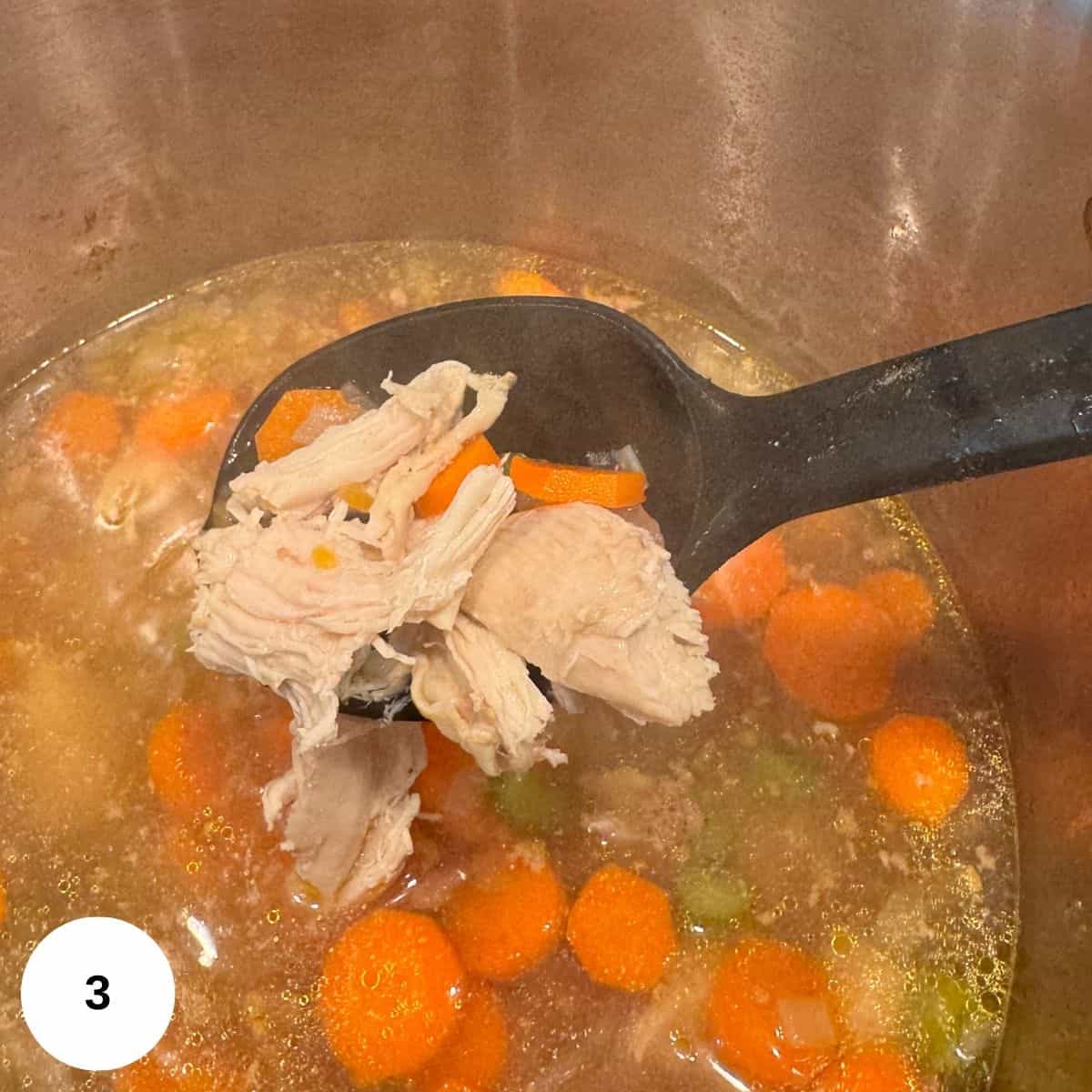 Adding the orzo and shredded chicken to the stockpot. 