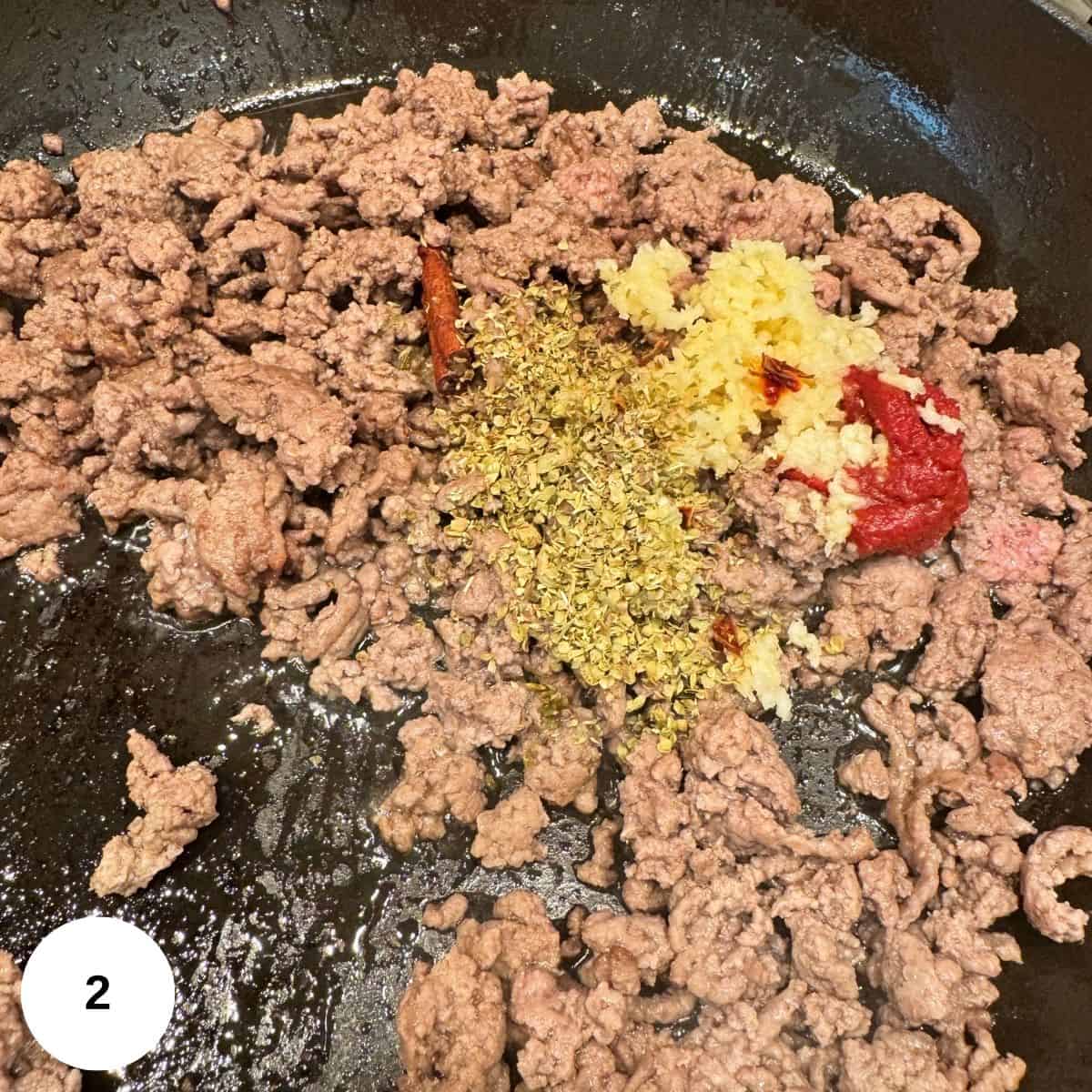 Making the lamb sauce on the stove with ground lamb and spices. 