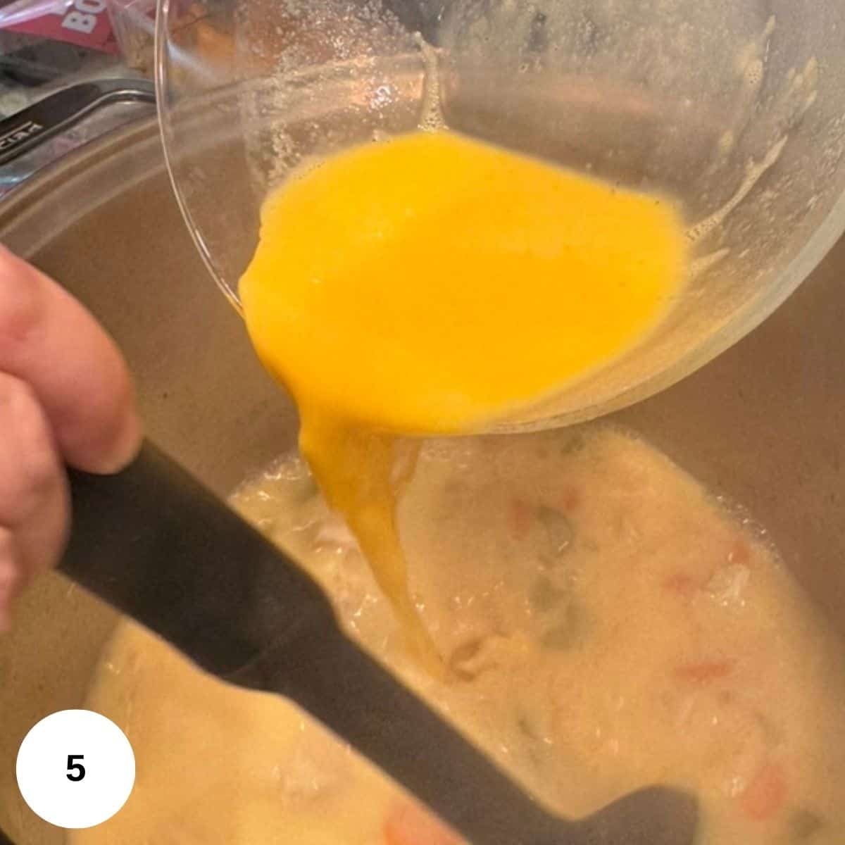 Adding the tempered eggs to the soup. 