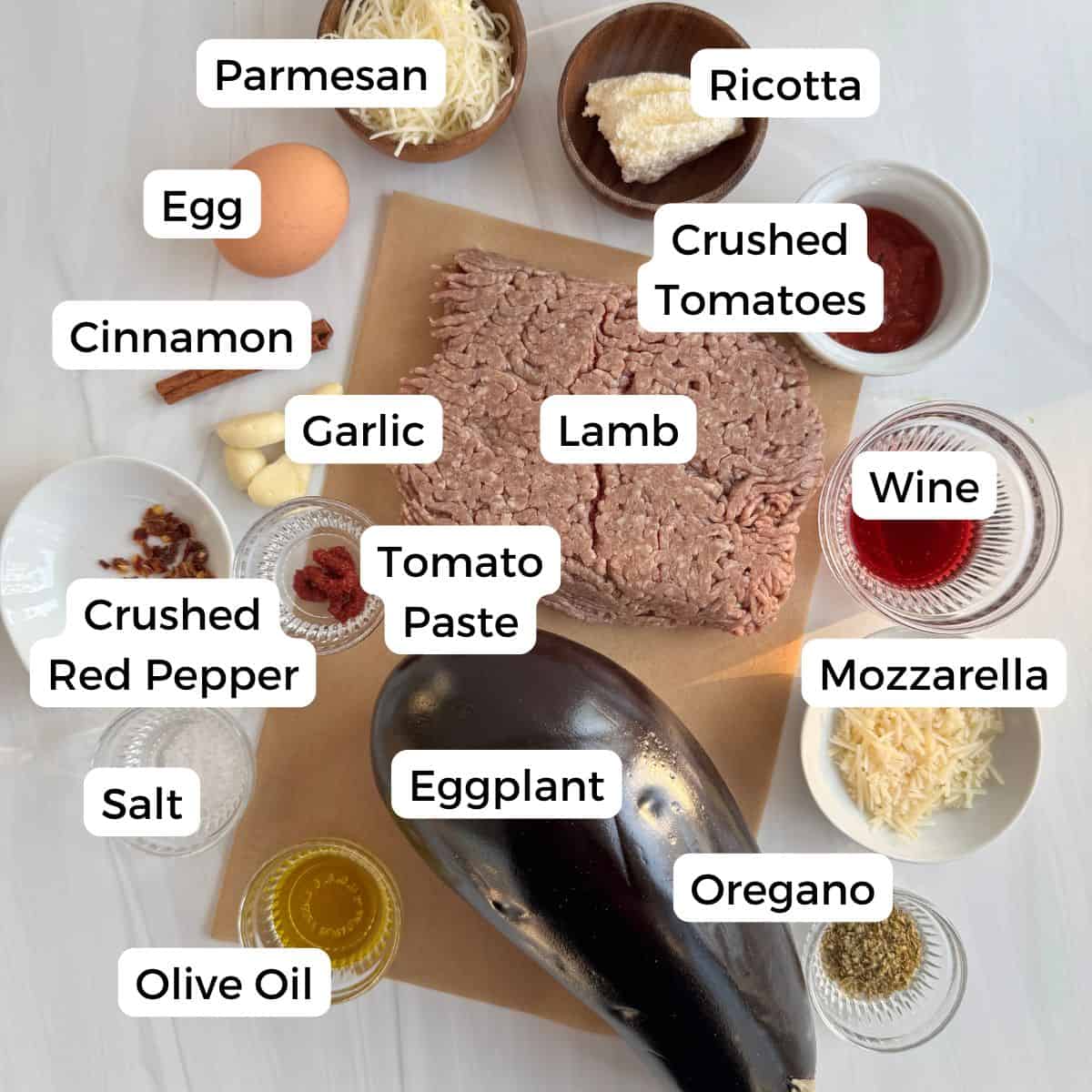 Ingredients include parmesan cheese, ricotta, crushed tomatoes, egg, cinnamon, garlic, lamb, wine, mozzarella, oregano, eggplant tomato paste, crushed red pepper, salt, and olive oil. 