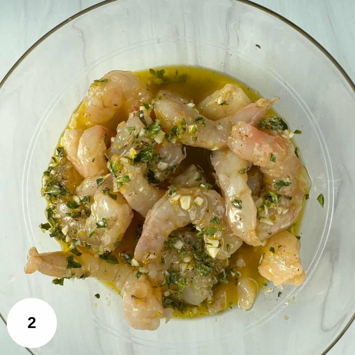 Adding the shrimp to the marinade in the bowl. 