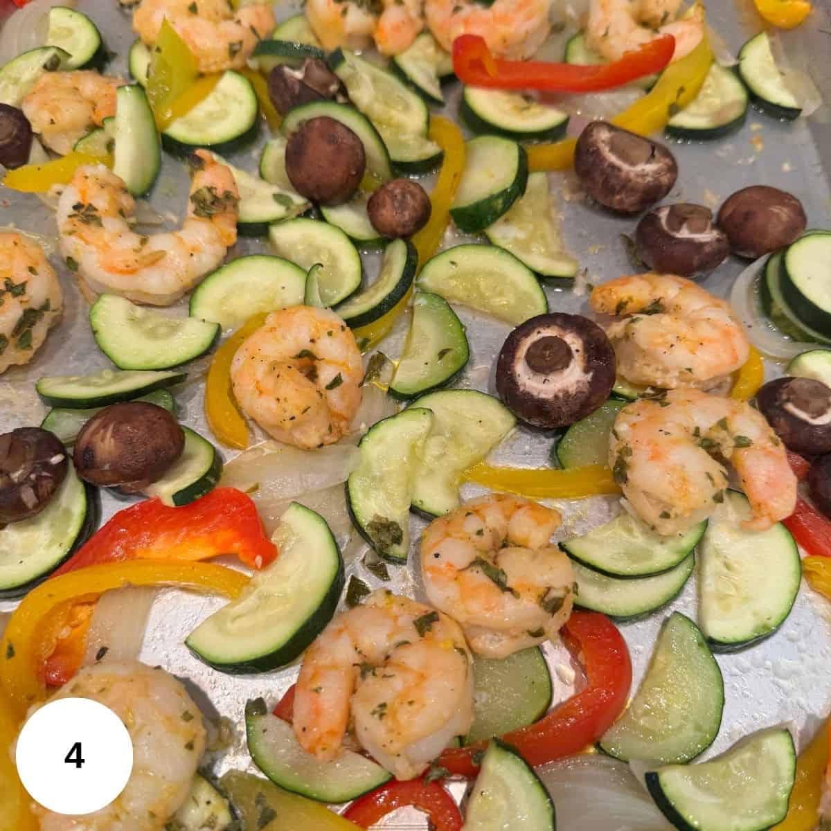 A picture of the shrimp and veggies cooked on a sheet pan. 