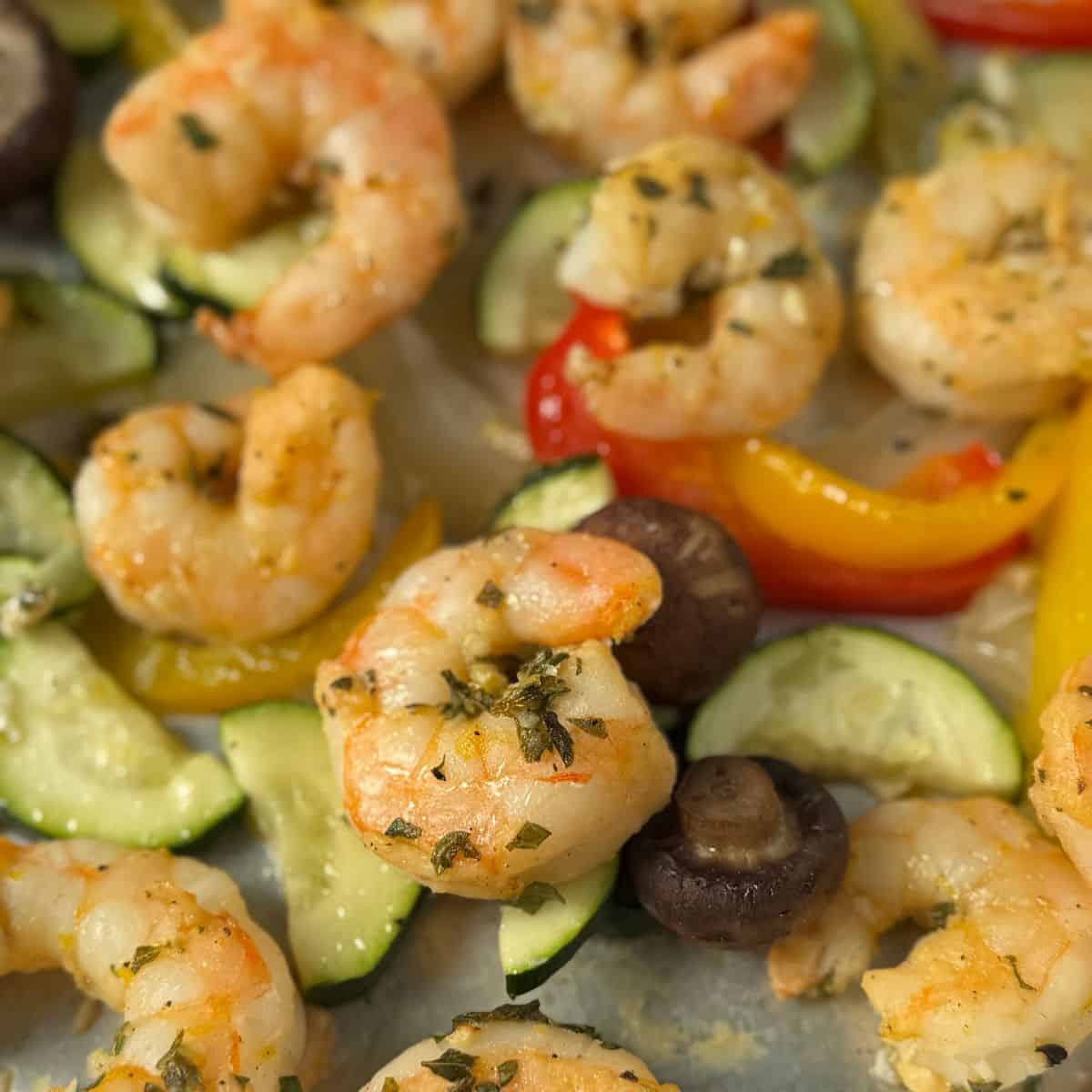 A picture focusing on a single cooked and marinated shrimp on the sheet pan. 