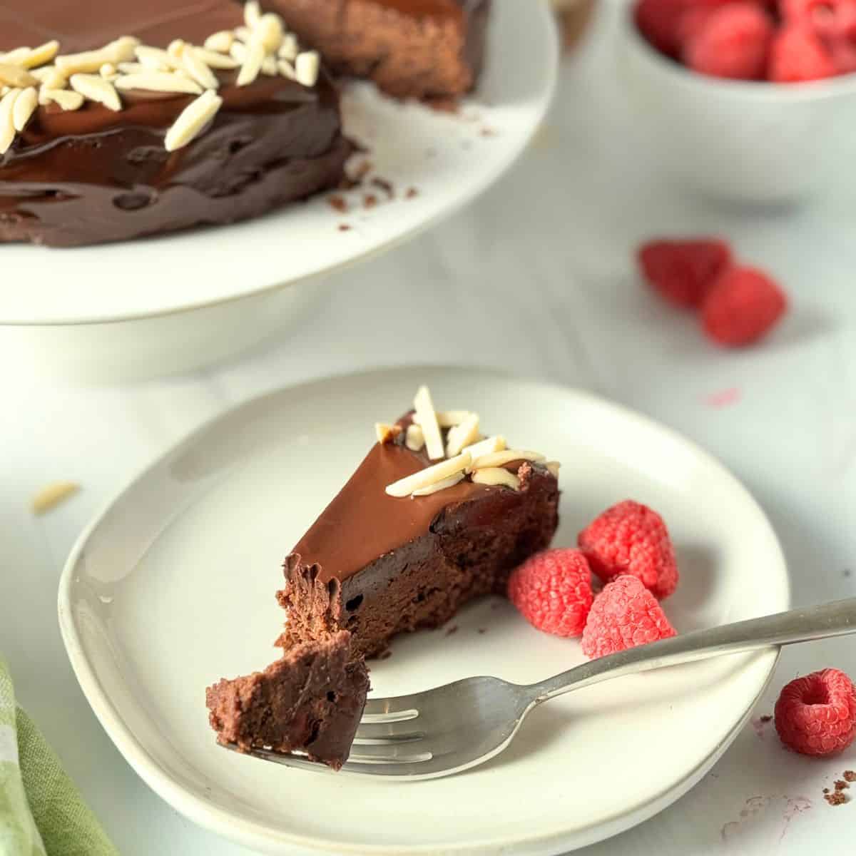 A slice of the cake on a white plate with a fork showing one bite. 
