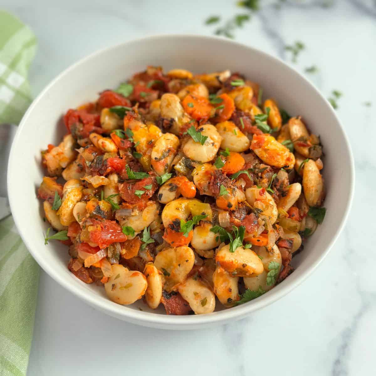 Greek baked beans in a white bowl. 