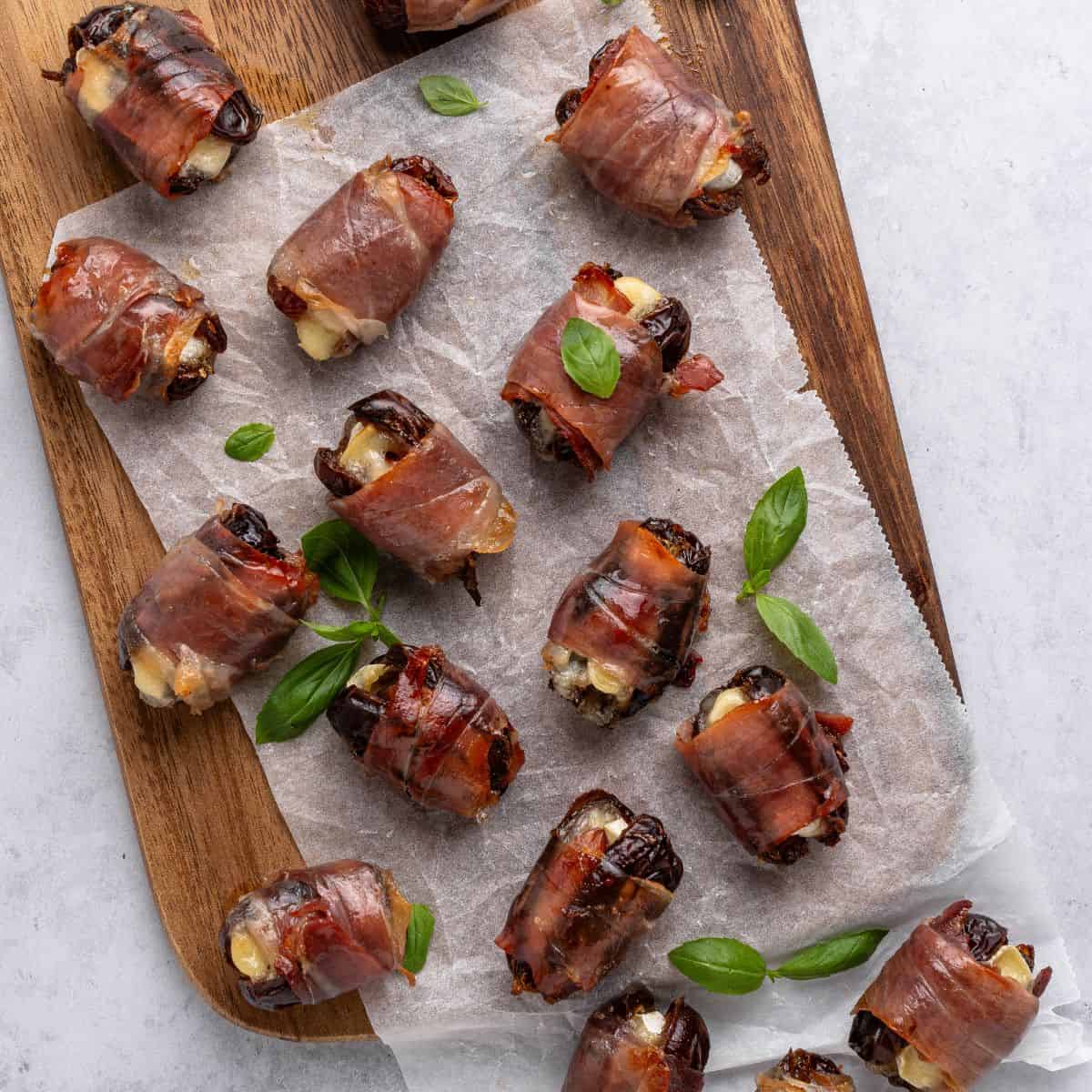 Dates sitting on a wooden cutting board. 