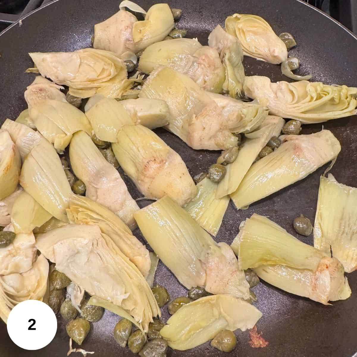 Starting the sauce by sauteeing artichokes and capers. 