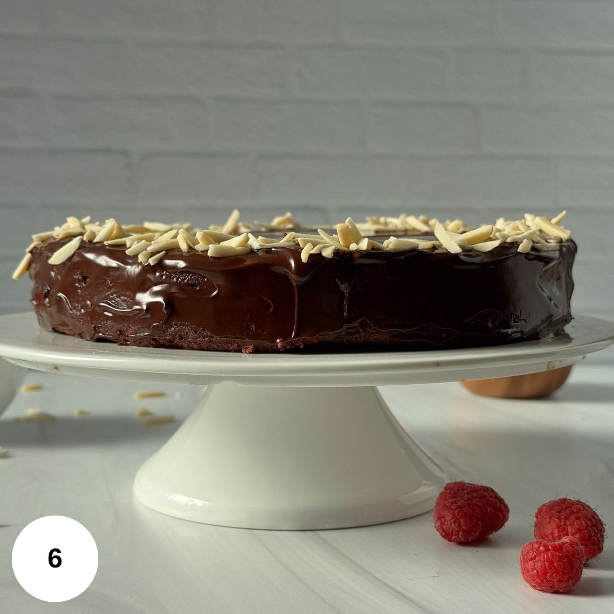 Showing the side of the finished cake that is sitting on a cake stand. 