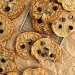 Gluten-free, dairy-free chocolate chip cookies on parchment paper and a wire rack.