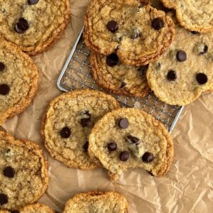 Gluten-free, dairy-free chocolate chip cookies on parchment paper and a wire rack.