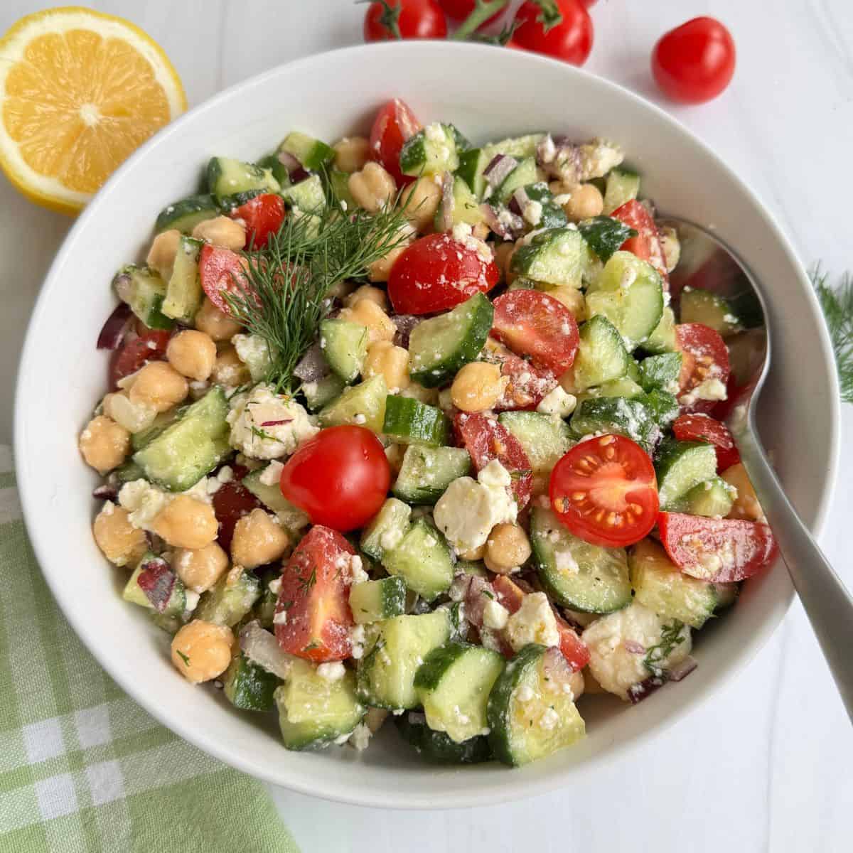 Chickpea Cucumber Feta Salad in a white bowl with a spoon.