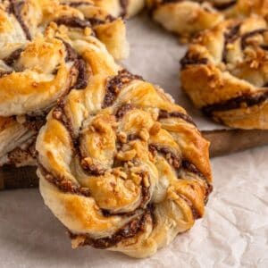 Nutella In Puff Pastry on a wooden board with parchment paper.